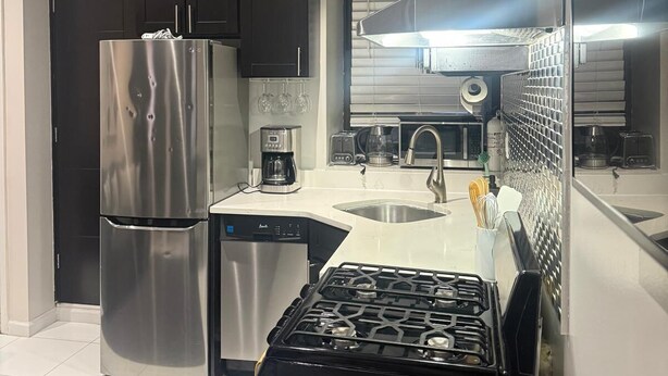 A modern kitchen with stainless steel appliances, a dishwasher, and a gas stove. - Discover the Comfort of Columbia University Area-1 (New York)