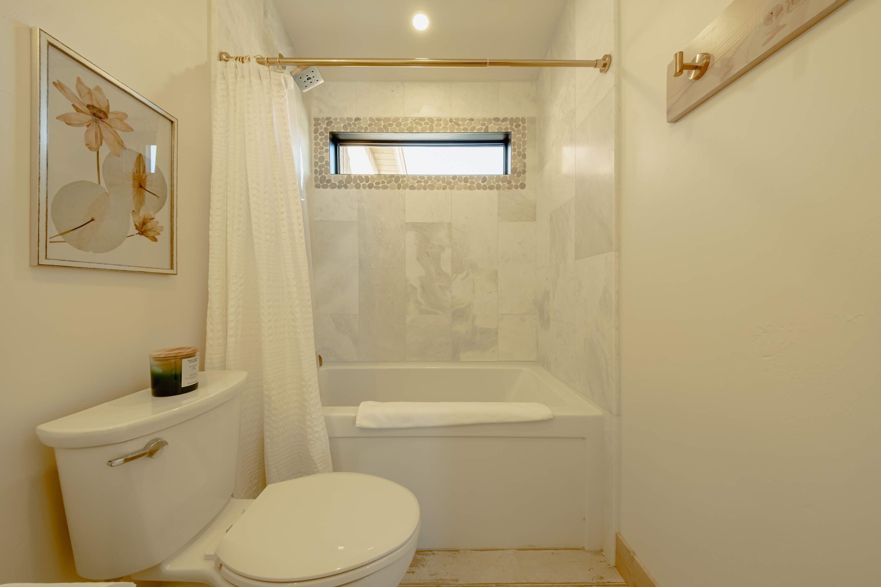 Een kleine badkamer met toilet, bad en douchegordijn.