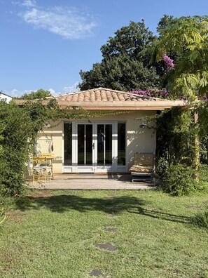 Una casa con techo de tejas, un porche cubierto y una puerta corrediza de vidrio.