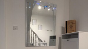 Ein Zimmer mit einem großen Spiegel, einem weißen Kleiderschrank und einem Teppichboden.