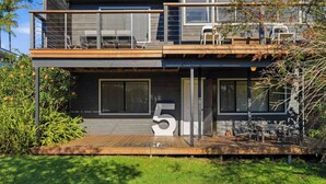 A two-story house with a balcony, outdoor seating, and a large number '5' displayed prominently. - Shack No. 5  by Book Jervis Bay - A Quirky, Retro Beach Escape in Jervis Bay! (Vincentia)