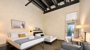 Habitación de hotel con dos camas, un sofá, una mesa y una ventana.