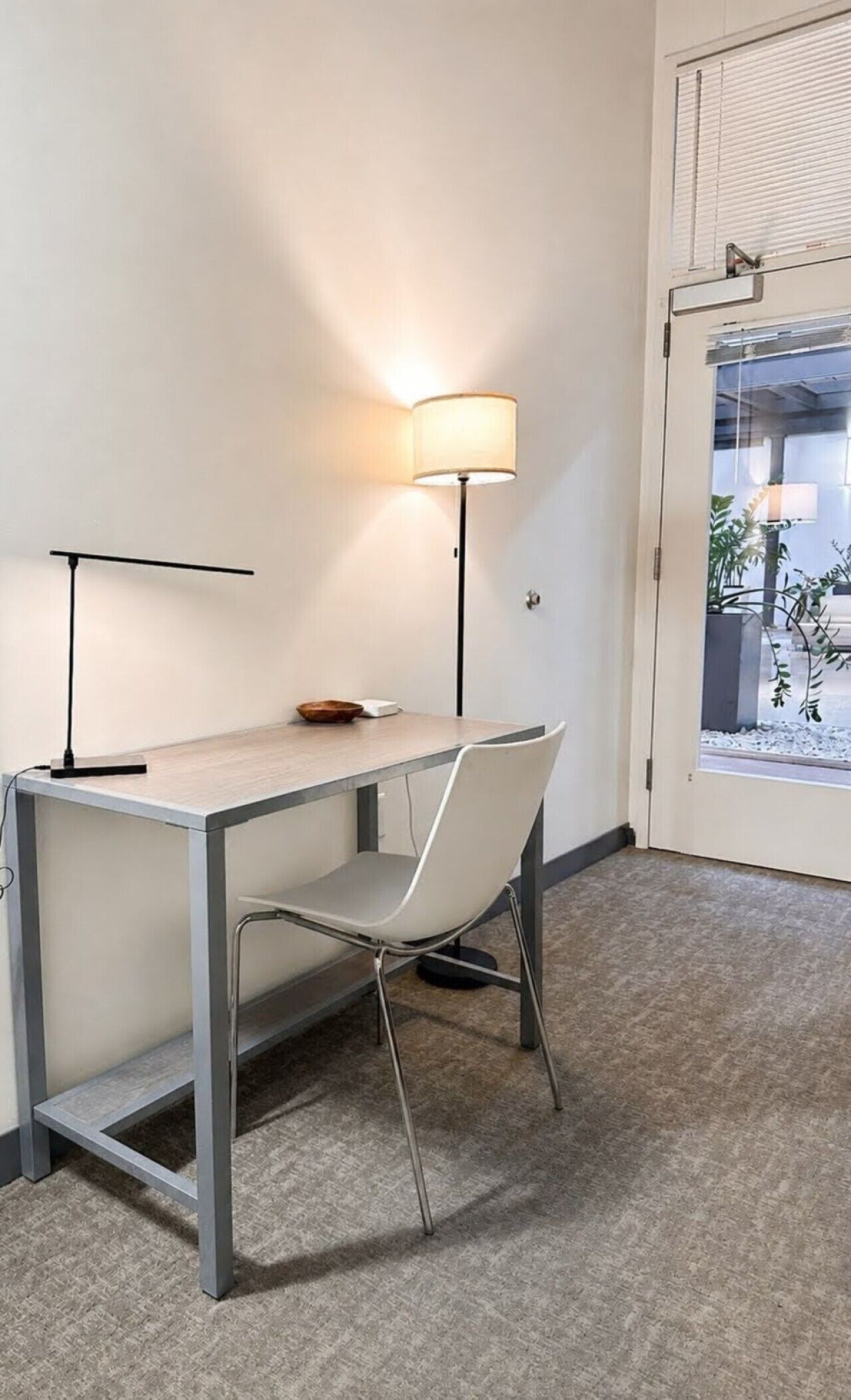 A compact office space with a desk, chair, and a lamp.
