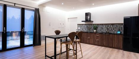 Una cocina moderna con comedor, ventanas amplias y vistas a un paisaje nevado.