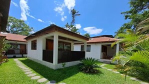 A two-story house with a covered porch, a well-maintained lawn, and a stone pathway leading to the entrance. - Puerto Azul  (Sauce)