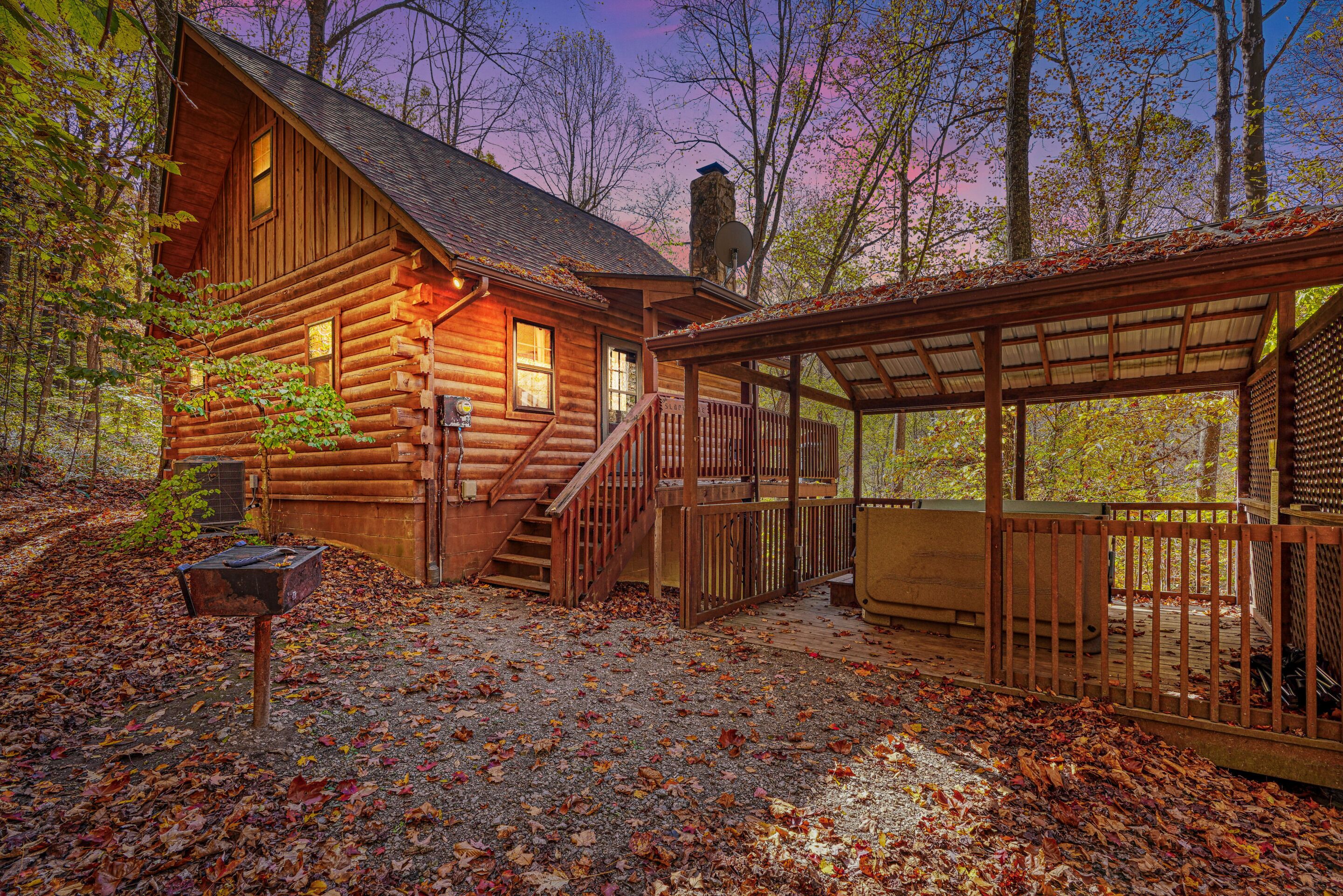 A log cabin with a covered porch and a chimney.