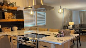 A modern kitchen with a central island, stainless steel appliances, and a built-in oven. - Charming 4-bedroom house with WiFi and AC in enchanting Houston (Houston)