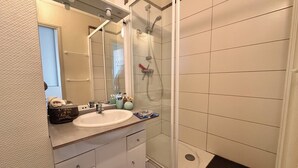 Un baño con lavabo, espejo y ducha.