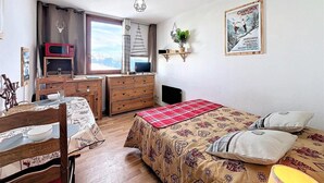 A bedroom with a bed, a desk, a dresser, and a window. - 50m from ski slopes, 14th floor, swimming pool, tv, ski locker, 16m², Le Corbier (Le Corbier)