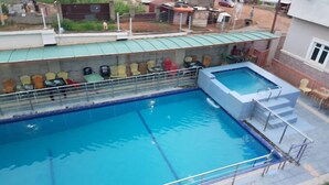 A swimming pool with a diving board and a small adjacent pool. - Stamford Hotels (Abuja)