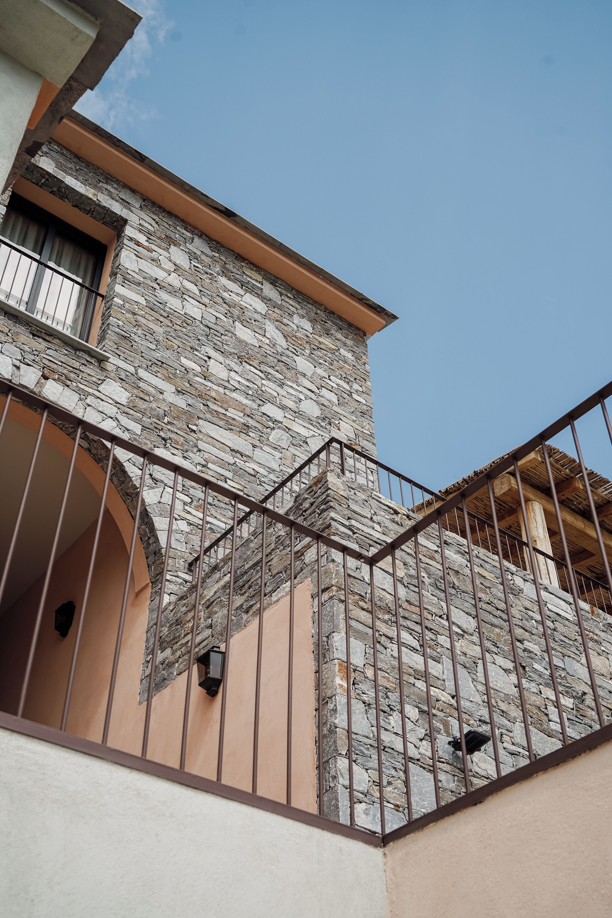 Un edificio de piedra con balcón y ventana.