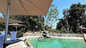 A clear swimming pool with a stone wall and wooden deck. - DOMAINE SANTA MARGHERITA (Castellare-di-Casinca)