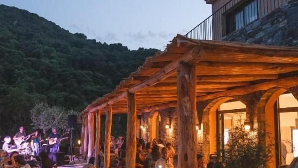 An outdoor dining area with wooden pergolas, tables, and chairs. - DOMAINE SANTA MARGHERITA (Castellare-di-Casinca)
