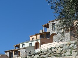 Um edifício de vários andares em pedra, com uma escadaria de pedra que leva à entrada.