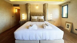 A large bed with a headboard, two bedside tables, and a framed picture on the wall. - DOMAINE SANTA MARGHERITA (Castellare-di-Casinca)