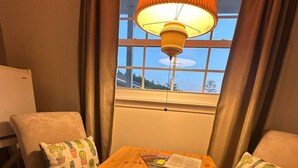 A cozy room with a wooden table, two chairs, and a window with curtains. - Room 4 - Prickly Pear double room (Manchester)