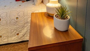 A bedroom with a bed, a bedside table with a lamp and a plant, a window with curtains, and a wall-mounted picture. - Alpine 5, cozy Vermont retreat (Manchester)