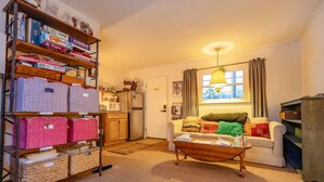 A cozy living room with a sofa, a coffee table, and a bookshelf filled with board games. - Alpine 5, cozy Vermont retreat (Manchester)