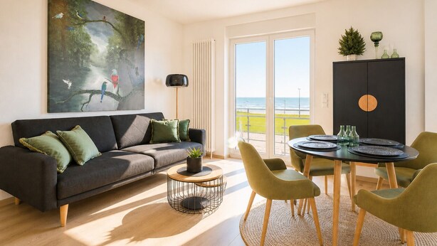 A modern living room with a sofa, a coffee table, and a dining table with chairs. There is a painting on the wall, a potted plant, and a view of the sea through the window. - Vacation apartment Gezwitschert (Norderney)
