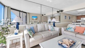 Un salon moderne avec un canapé, une table basse et un coin repas agrémenté d’une lampe.