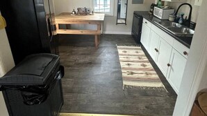 A compact kitchen with a refrigerator, microwave, and sink.