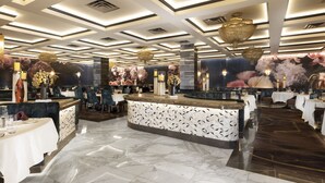Un restaurante espacioso con barra central, suelo de mármol y diseño moderno del techo.