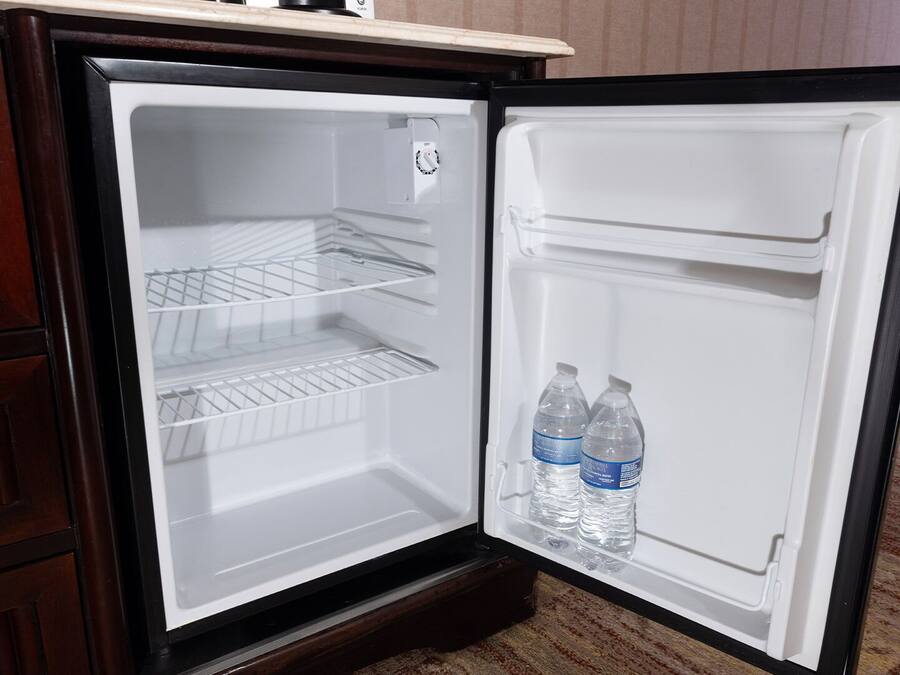 An open refrigerator with two water bottles on the door shelf.