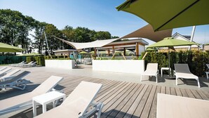 A poolside area with lounge chairs and umbrellas. - Holiday Home With gas Fireplace & Bath (Bemelen)