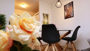 A dining area with a table, chairs, and a vase of flowers.