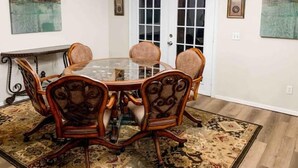 A dining room with a glass-top table, six upholstered chairs, a patterned rug, and a white door with glass panels. - ★Clean&Fresh★3BR/2BA★EZ access to S LBK/S Loop 289 (Lubbock)