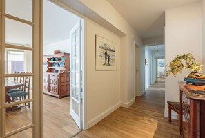 Stunning hallway with a large artwork, potted plant, and classic wooden cabinet.