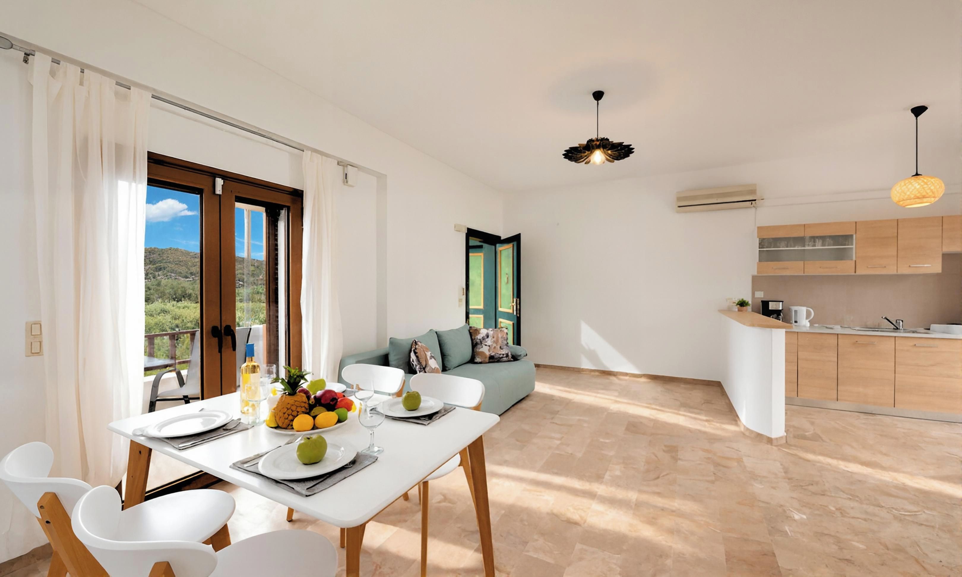 Un comedor moderno con una mesa dispuesta para dos personas, un sofá y una cocina al fondo.