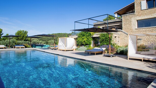 Une piscine avec des chaises longues et une pergola.