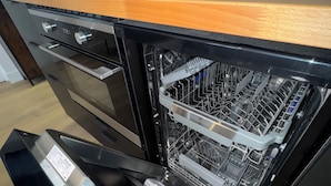 A kitchen with a dishwasher, oven, and wooden countertop. - Facing the castle & Air-conditioned ~ El Castillo ~ (Surgères)