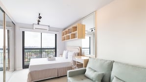 Una camera da letto moderna con un letto, una scrivania e un balcone.