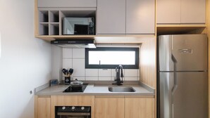 Una cucina compatta con forno a microonde, forno e frigorifero integrati.
