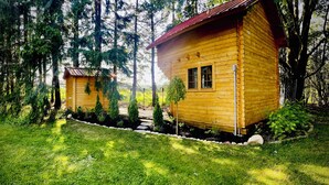 A wooden cabin with a red roof, surrounded by a well-maintained garden and tall trees. - Cozy Belwood Bunkie Retreat - 10 Min to Elora Gorge (Belwood)