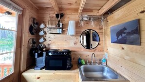 A compact kitchen with a microwave, coffee maker, and glassware. - Black Bear, Black Bear Lakefront Cabin (Cantwell)
