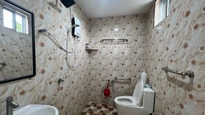 Een badkamer met een wastafel, toilet, douche en raam.