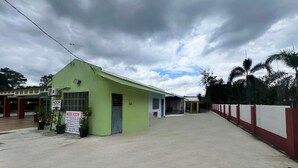 Een groen gebouw met een bord waarop staat dat er een kamer te koop is.