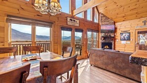 Eine Holzhütte mit Essbereich, Kamin und einem Schild, das auf einen Rückzugsort in Tennessee hinweist.