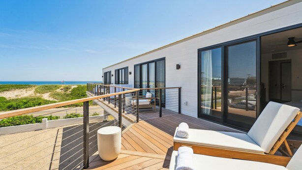 A modern outdoor deck with lounge chairs and a view of the beach. - Offshore Montauk (Montauk)