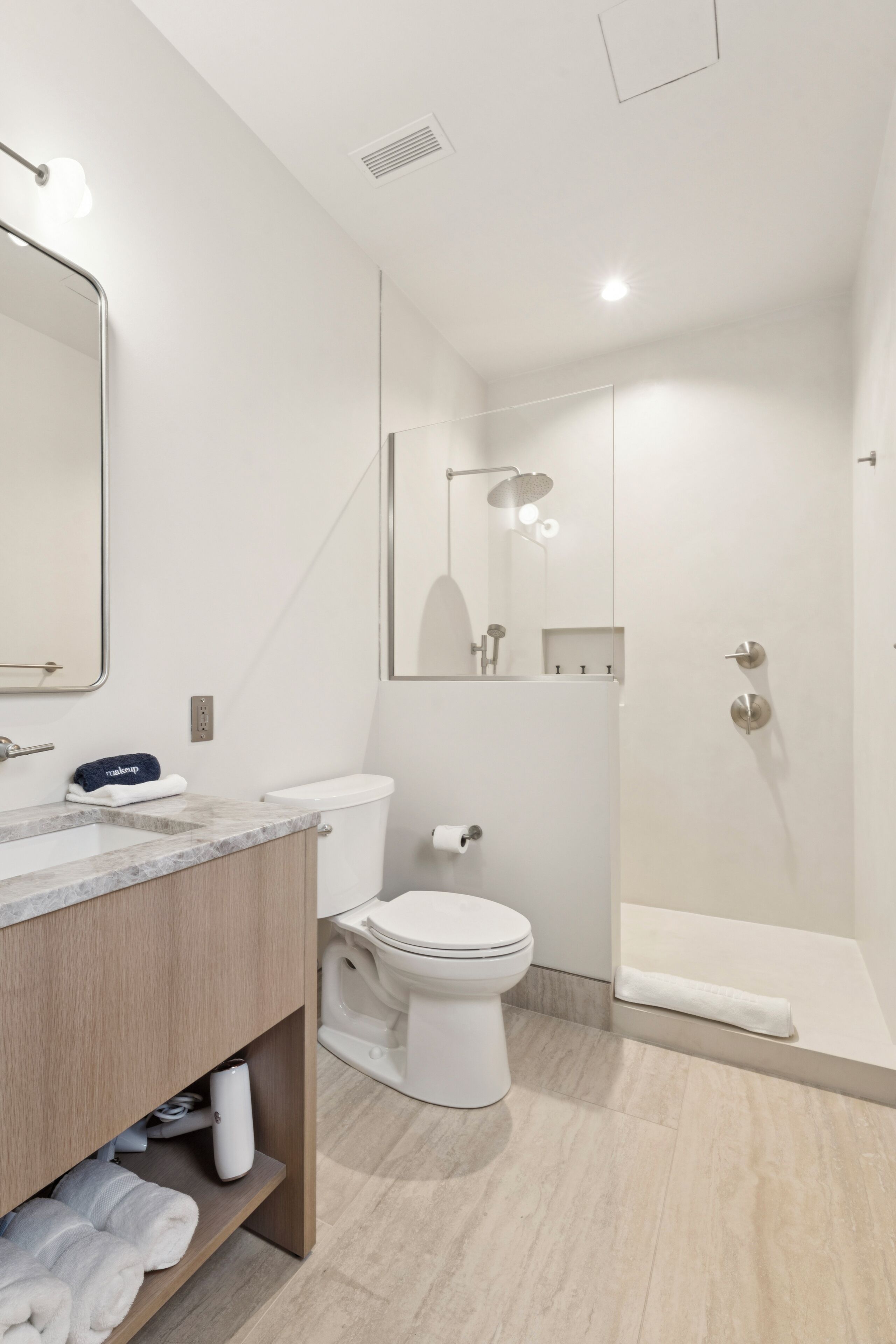 A modern bathroom with a toilet, sink, and shower.