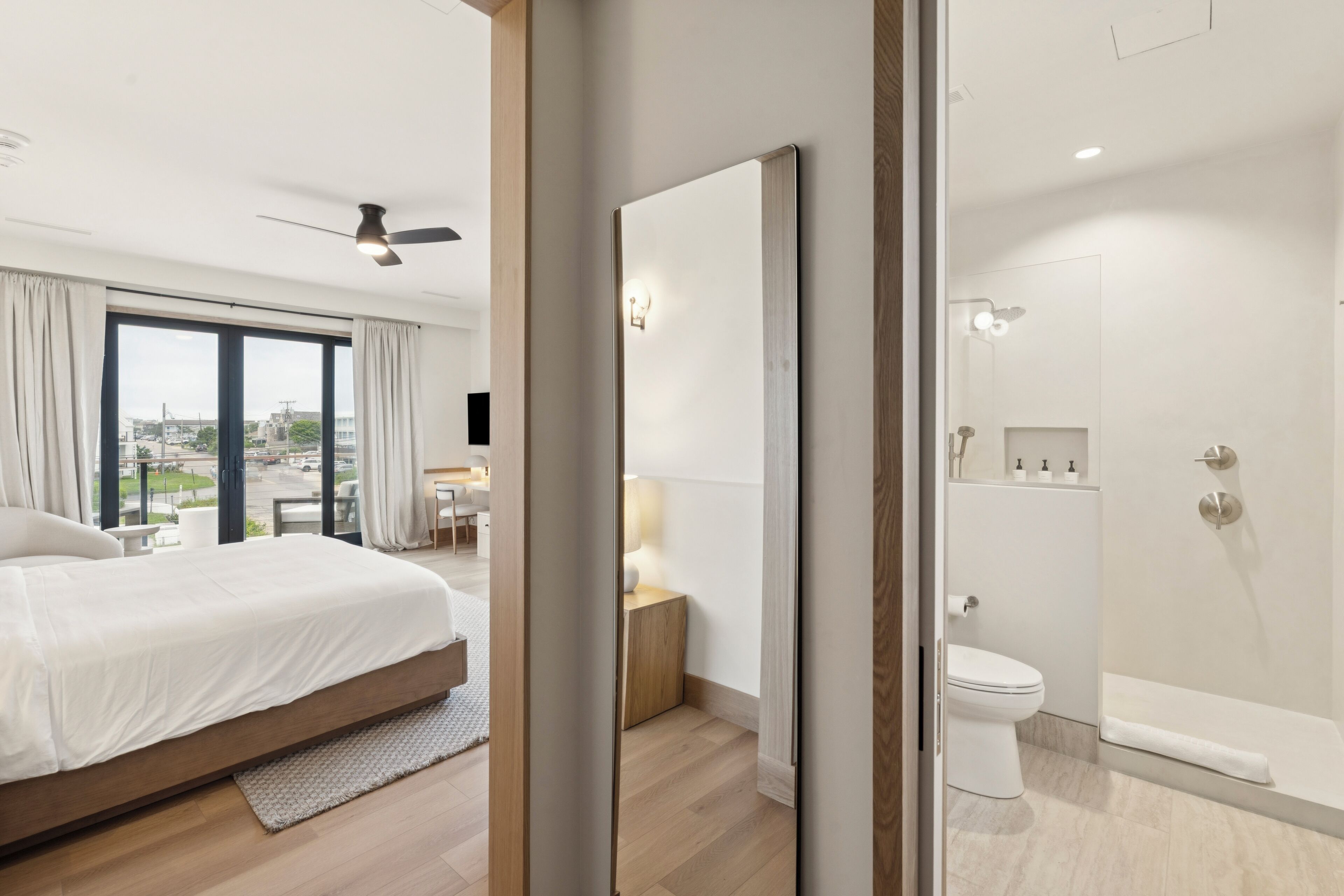 Une chambre d’hôtel moderne dotée d’un grand lit, d’une salle de bain avec douche et offrant une vue sur la ville par la fenêtre.
