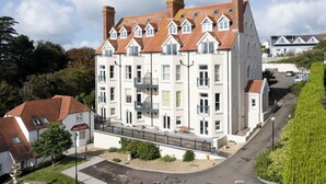 A multi-story residential building with a symmetrical facade, multiple chimneys, and a central staircase. - 10 Mansion House - Indoor Pool, Sea Views, Gym (Tenby)