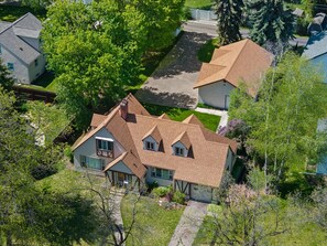Et boligområde med et hus, et saddeltag, en veranda og en velplejet græsplæne.