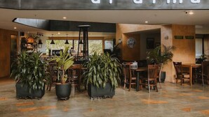 A modern interior with a 'al.alma' sign, wooden furniture, and potted plants. - Suites - Hotel Rioverde (Rionegro)