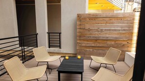 A patio with a black table and four wicker chairs, two glasses of orange juice on the table. - Sosuite at The Jefferson (Philadelphia)