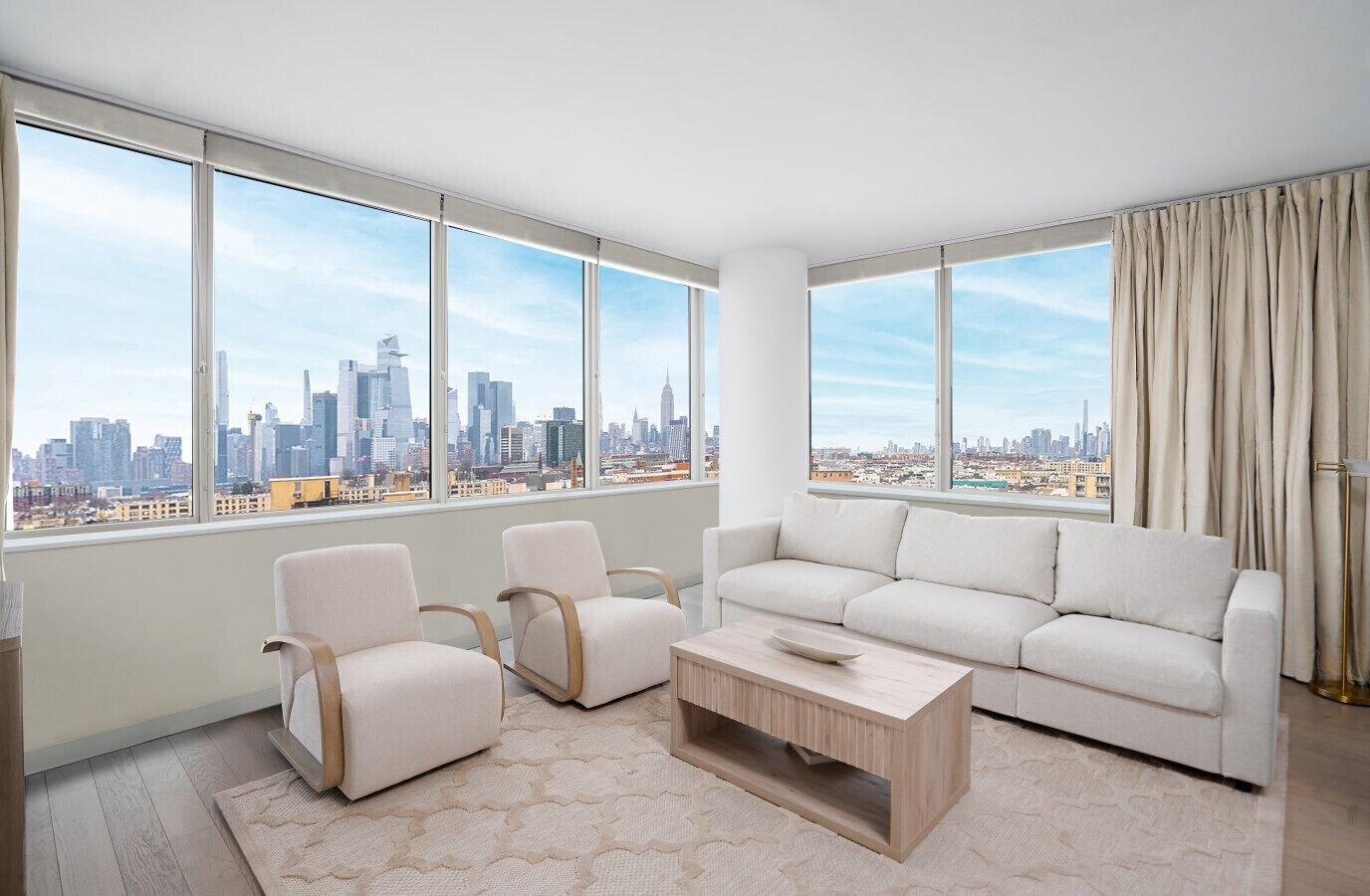 Een moderne woonkamer met een groot raam en uitzicht op de skyline van de stad, een witte bank, twee fauteuils en een houten salontafel.