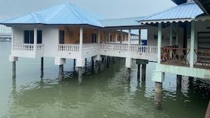 Un edificio sul lungomare con una passerella coperta sopra l'acqua, sostenuta da colonne.